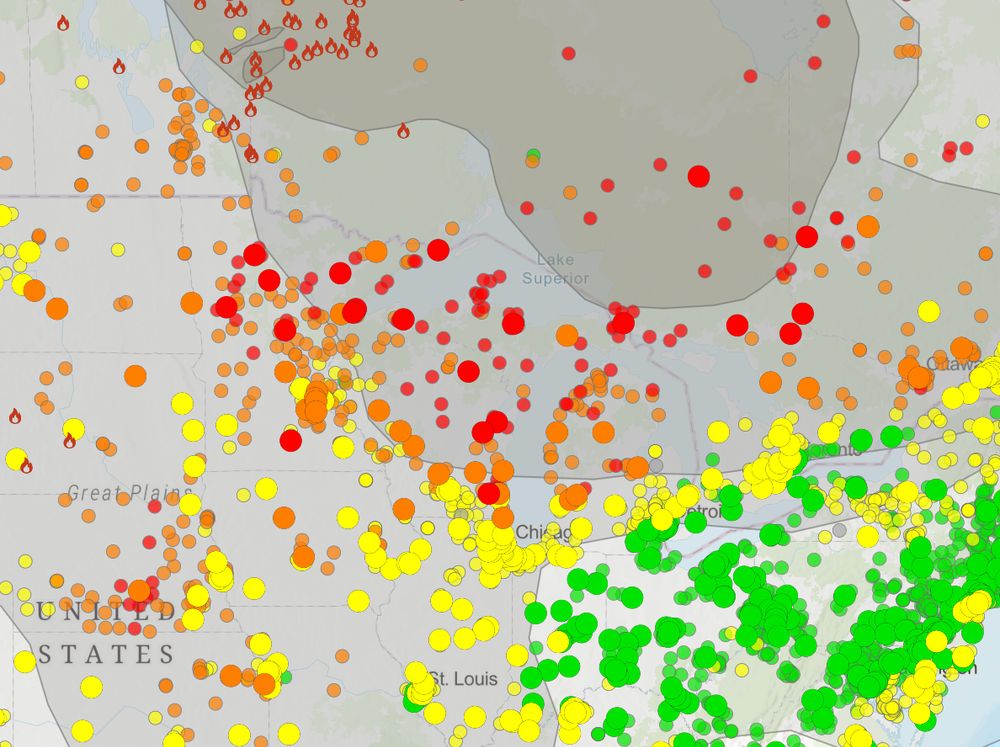 Map of northern US showing gray smoke plumes coming from fires in Canada as well as many colored dots, with red and orange indicating less healthy air across Minnesota, Wisconsin, and Michigan