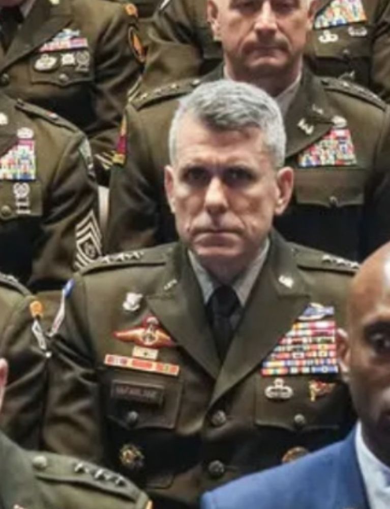 A general staring at the camera with a fierce and slightly panicked gaze that screams "get me out of here"