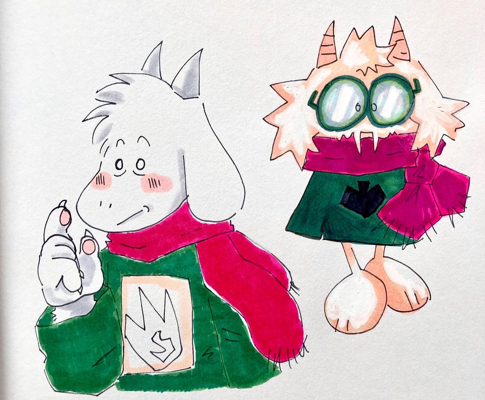two marker drawings of ralsei from deltarune. 

the one on the left is based off toby fox's original drawings of ralsei, with a more "snoopy" or "moomin" looking design. he has no glasses, and a fire-shaped patch on the center of his cloak. 

the one on the right is a more "chibi" or "cutesy" version of ralsei, based off his chapter 1 design and my own interpretations, with parts of his chapter 2 design sprinkled in. his arms aren't visible and his scarf is tied in a knot. 