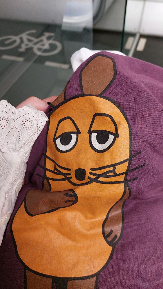 ein lila Stoffbeutel mit der Sendung mit der Maus Maus drauf