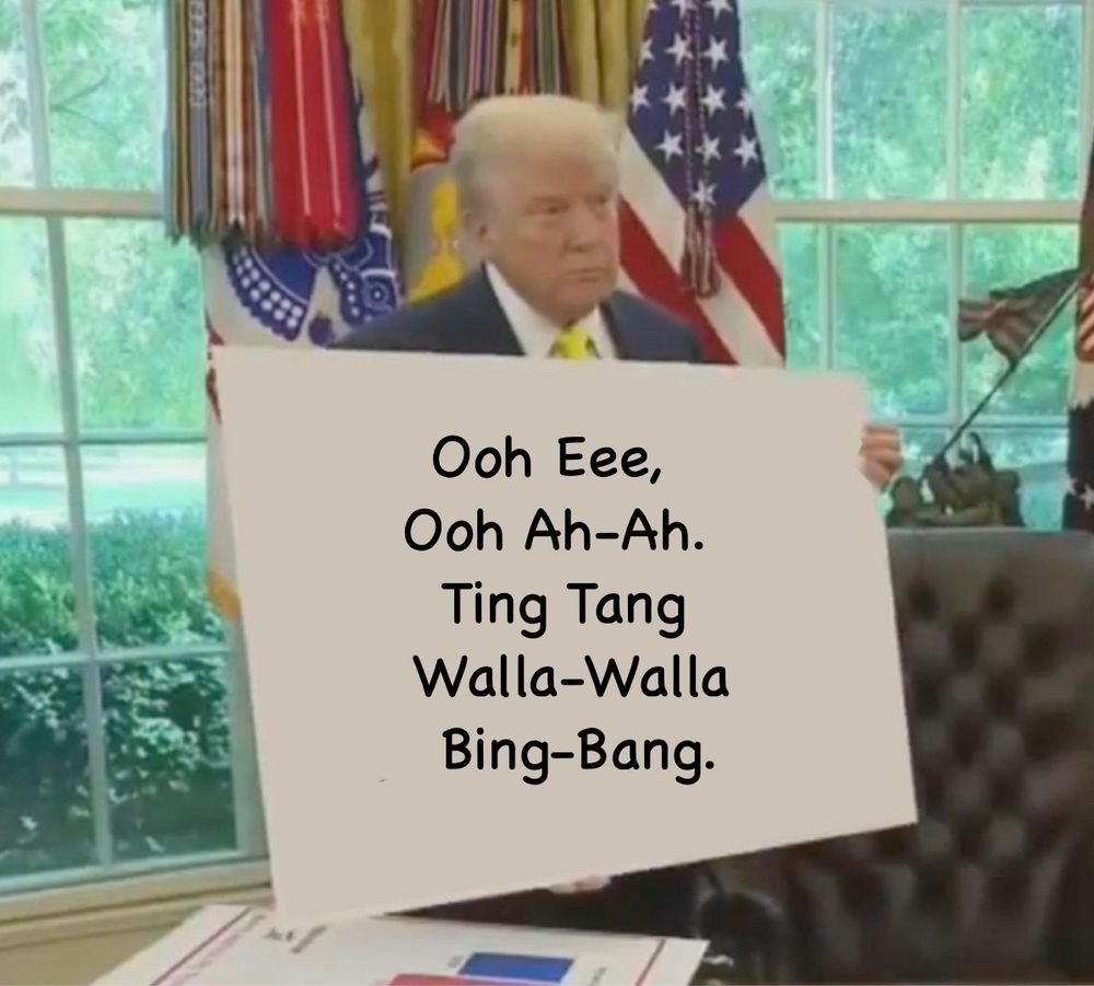 Donald Trump holding a sign which reads: Ooh Eee, Ooh Ah-Ah. Ting Tang Walla-Walla Bing-Bang.