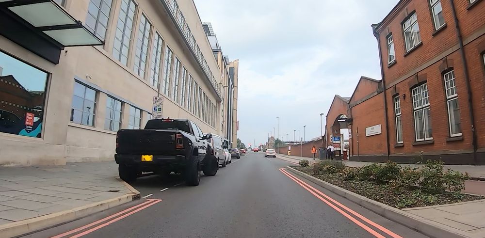 An emotional support pickup truck, the wheels on the left right into the kerb, the wheels on the right hanging out the bay.

On the opposite side of the road is some suss and a cycleway 