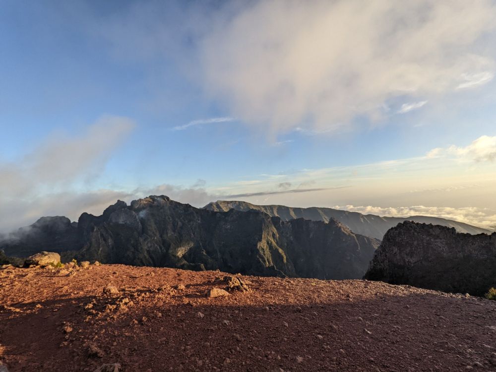 mountains with red soil in the foreground