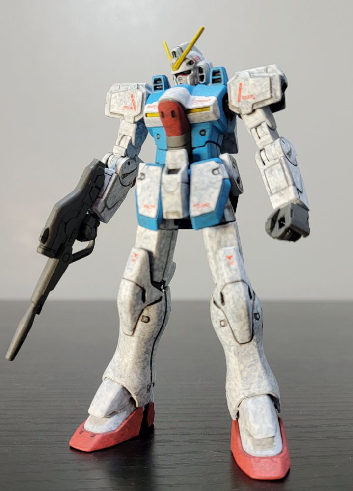 HGUC 1/144 LM312V04 Victory Gundam. It is fully repainted in its standard colors. The model is standing on a black table with a white wall in the background. 