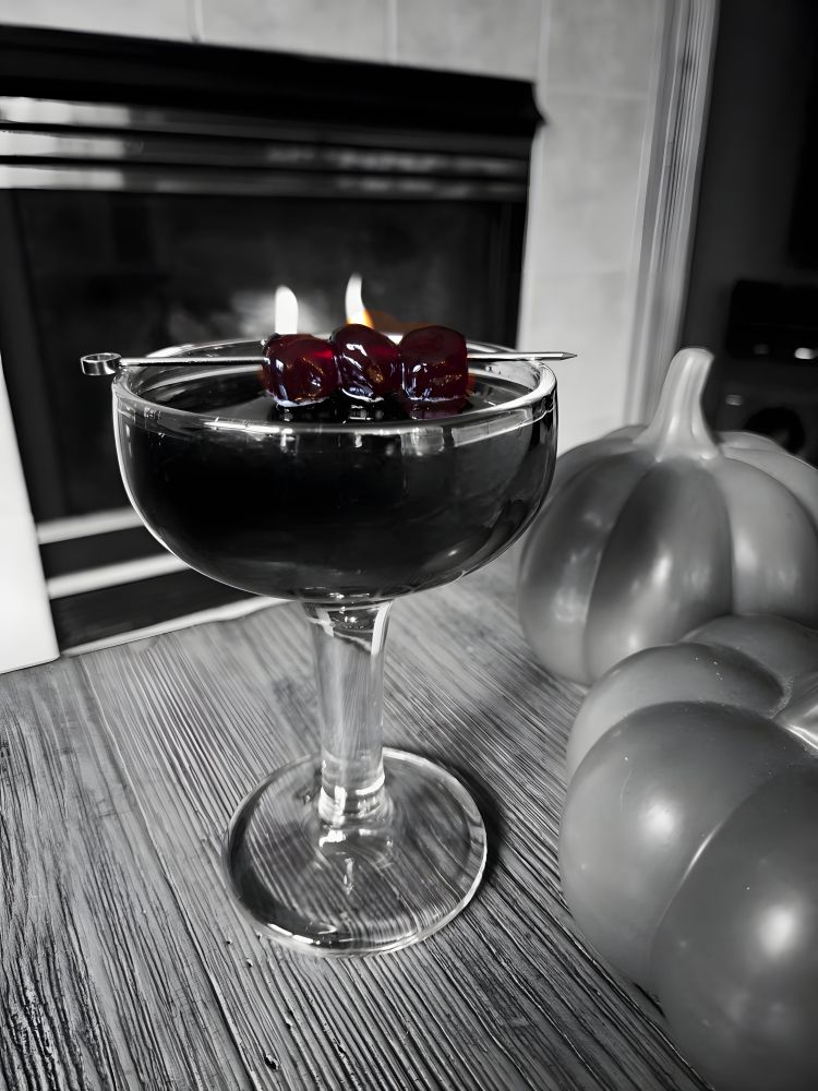 Dark cocktail with three Luxardo cherries