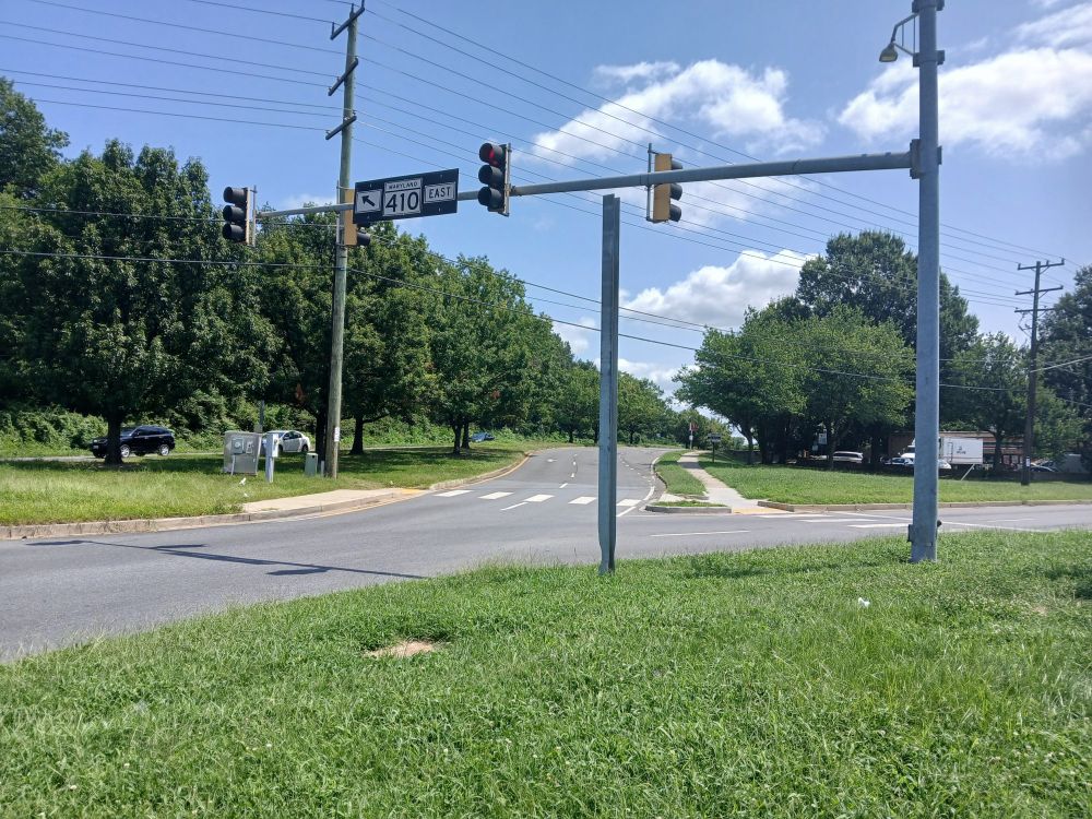 In Prince George's County, Maryland, intersection of East-West Highway and Ager Road. In foreground on a traffic island, an empty metal sign support.