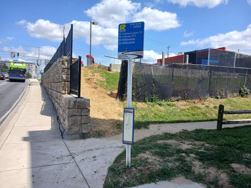 In Silver Spring, Maryland, on Piney Branch Road near University Boulevard, a sign pole with (from top) a Ride On bus stop sign and a Metrobus J4 timetable.