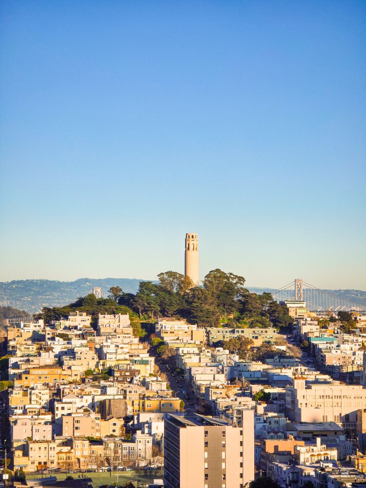 The simple fluted tower is named for Lillie Hitchcock Coit, a wealthy eccentric and patron of the city’s firefighters. Coit died in 1929, leaving a substantial bequest “for the purpose of adding to the beauty of the city I have always loved.” The funds were used to build both the tower and a monument to Coit’s beloved volunteer firefighters, in nearby Washington Square. The tower was designed by the firm of Arthur Brown, Jr., architect of San Francisco’s City Hall. Contrary to popular belief, Coit Tower was not designed to resemble a firehose nozzle.