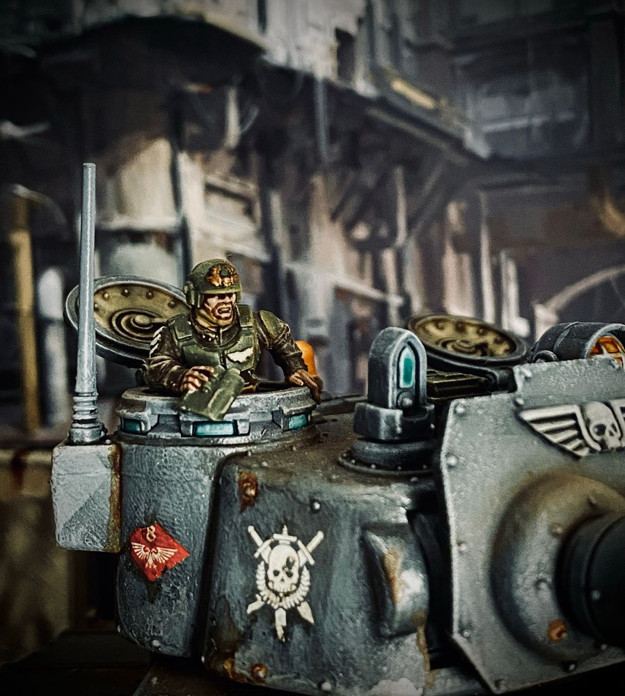 Tank Commander Lieutenant Clark with binoculars looking out of a hatch in the turret of the tank 