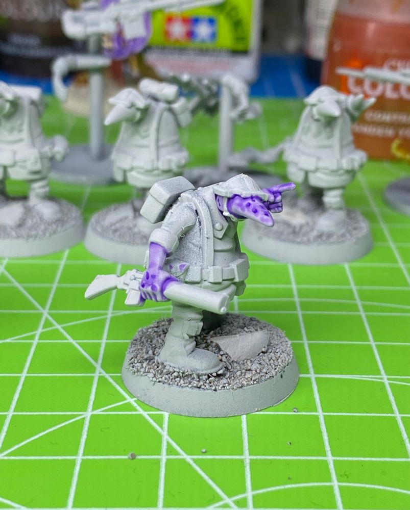 Another grey primed WIP Quar Crusader with purple freckled skin holding a Bogen rifle. Standing on a bright green cutting board.