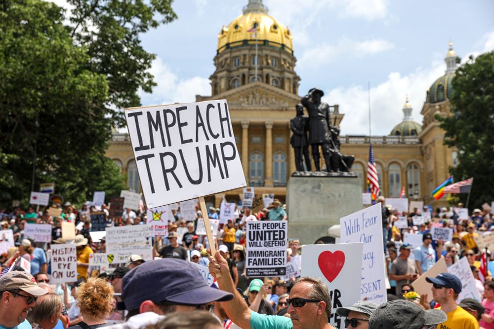 A crowd of protesters gathers outside a state capitol building in Des Moines, carrying signs, including one which reads 'Impeach Trump.' (Fritz Nordengren / ZUMA Press Wire / Reuters)