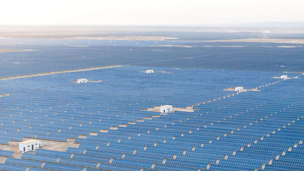 An aerial view—solar panel grids in a desert, stretching to the horizon (CFoto / Future Publishing / Getty)