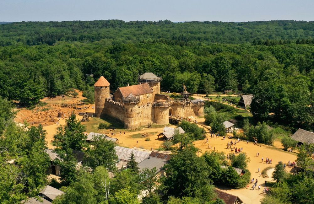 An aerial view of a small medieval-style castle in a wooded area. (Aufort Jerome / Getty)