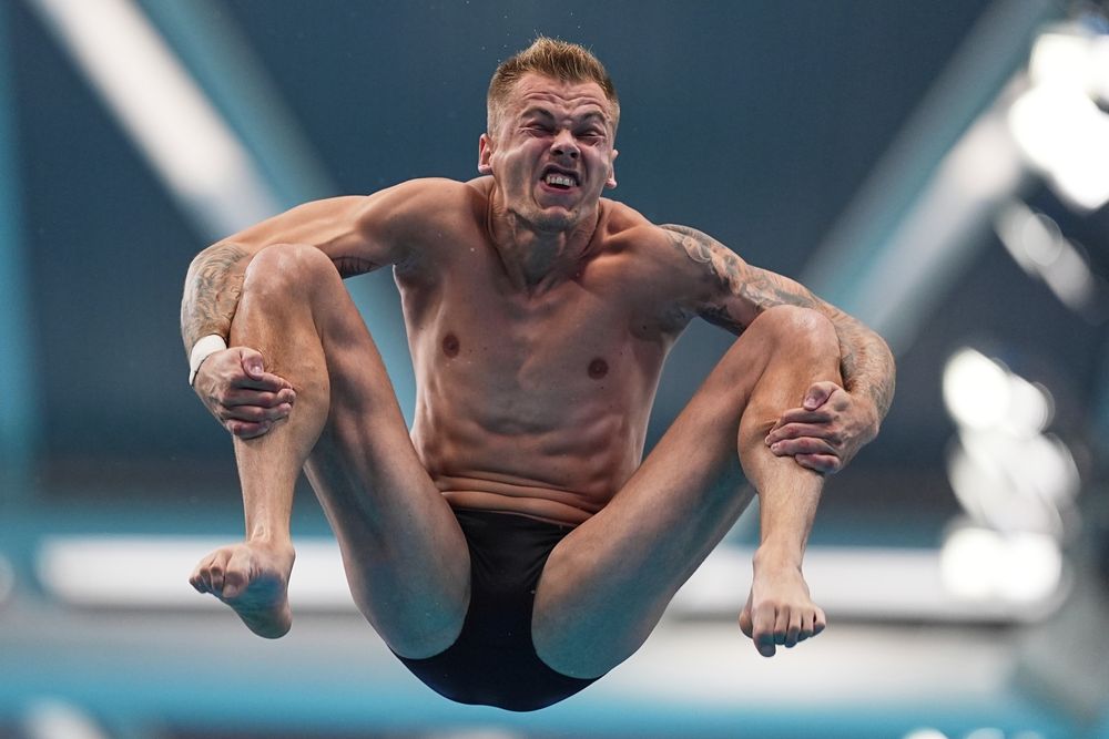 A diver's face is distorted as they tumble in the air during a diving competition. (Ng Han Guan / AP)
