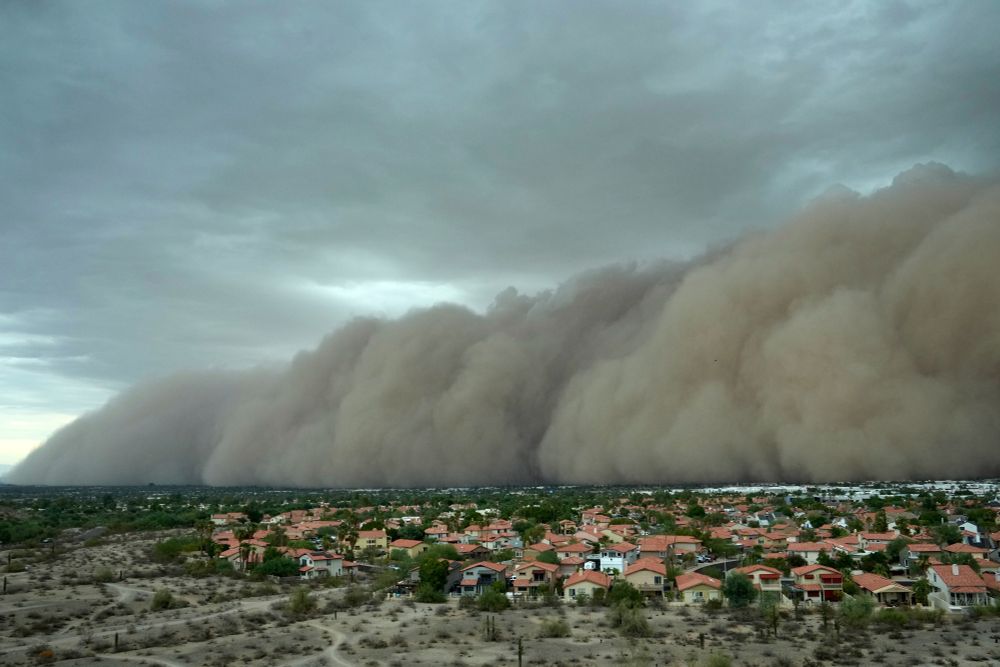 An enormous rolling cloud of dust approaches a residential area. (Ross D. Franklin / AP)