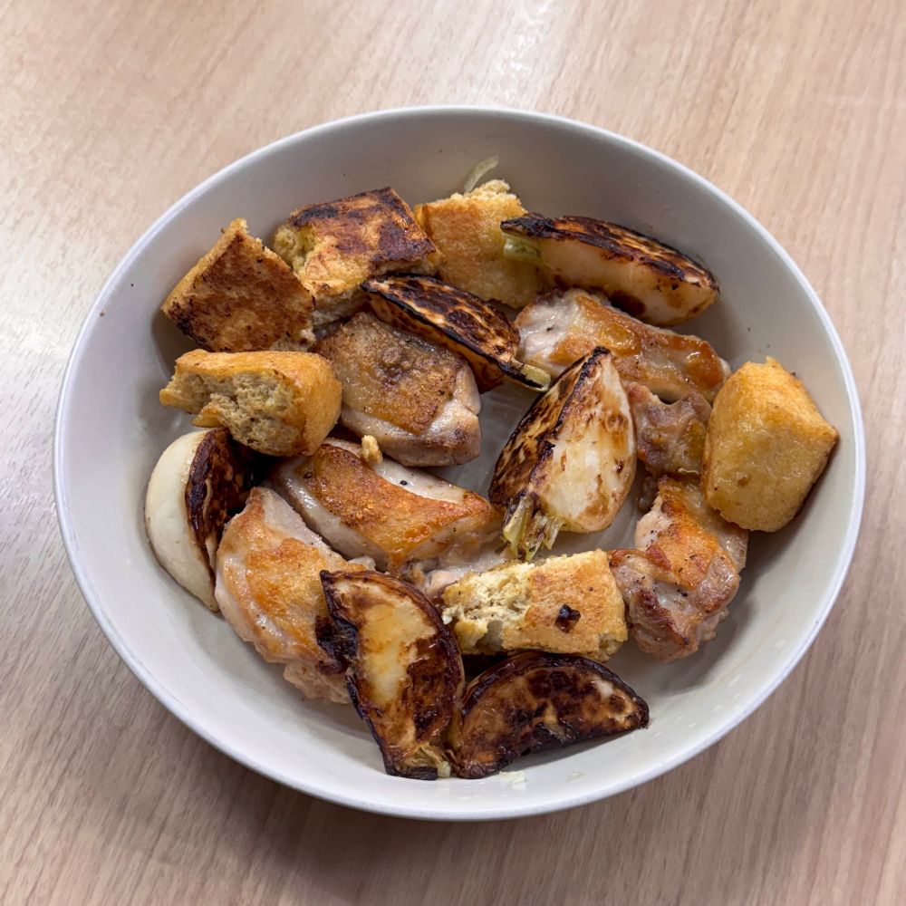 焦げ目のついたかぶ、鶏もも肉、油揚げが白い皿によそわれています。