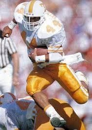 A photo from around 1990 showing a man running with a football. His shoulder pads are enormous.