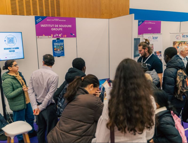 Des jeunes devant le stand du Groupe Institut de Soudure, avec le simulateur de soudage, pendant l'événement "Bercy fait  son industrie" du 21 novembre 2024