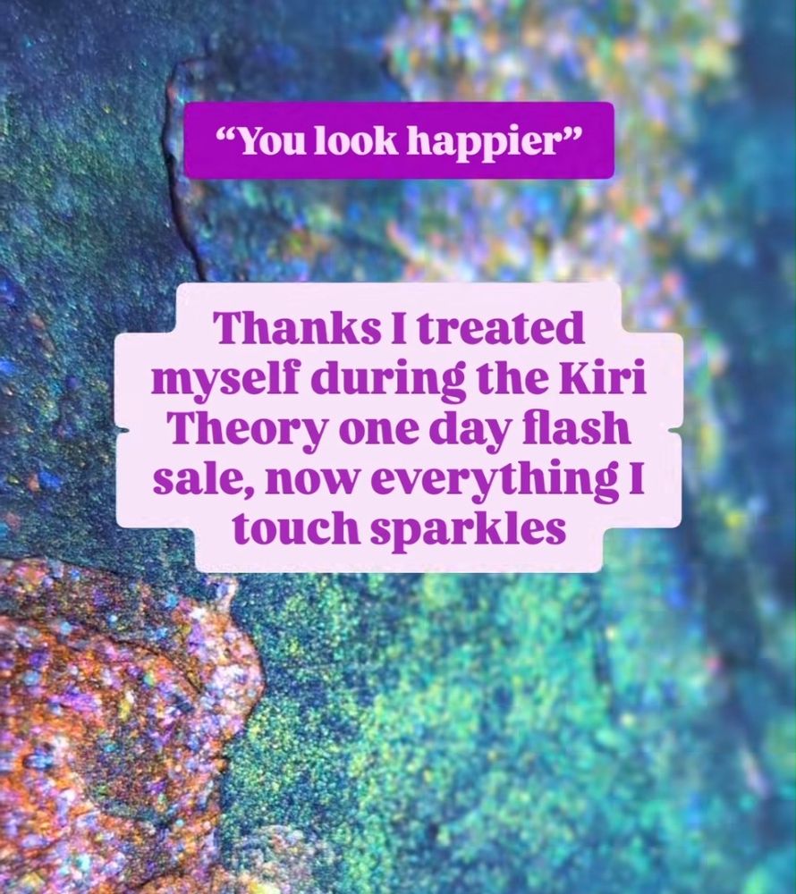 Two text blocks in shades of purple, shown over a close up of very sparkly opalescent textured abstract art in colors of purple, golden turquoise, and orange with rainbow flakes. The top text reads "You look happier" followed by "Thanks I treated myself during the Kiri Theory one day flash sale, now everything I touch sparkles"