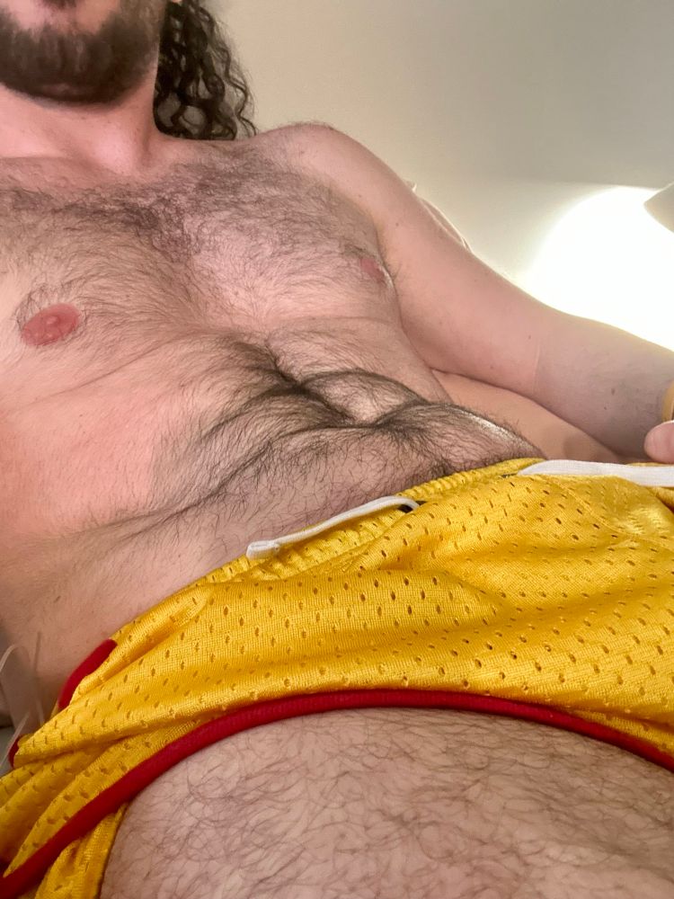 Bauhaus torso and thigh wearing only a pair of short yellow mesh athletic shorts