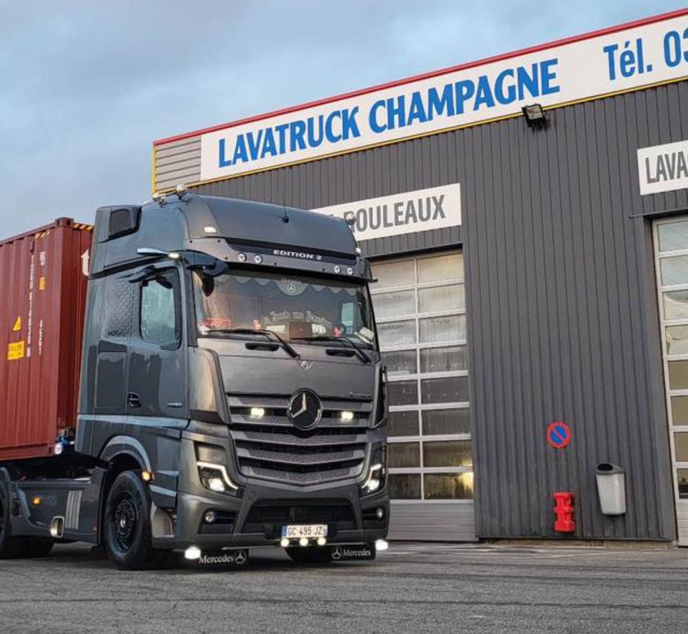 A large semi truck in front of a building with a "Lavatruck Champagne" sign.