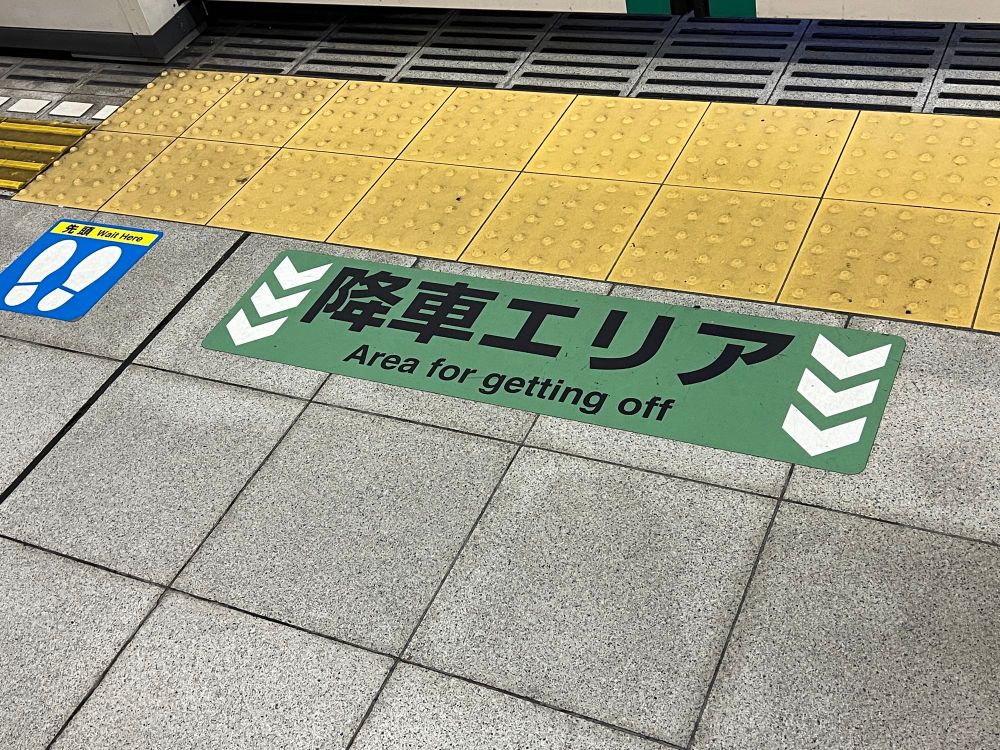 Floor markings to identify where people will be exiting the train (in Kyoto). Text reads: "Area for getting off"