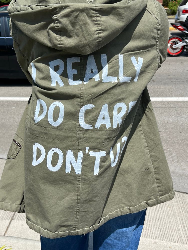 The back of a jacket with "I really do care, don't u?" written on it.