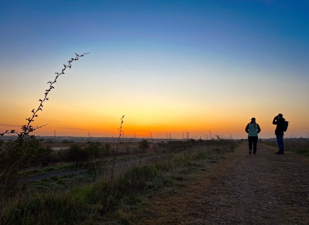 Two birdwatchers just before sunrise by The Thames.