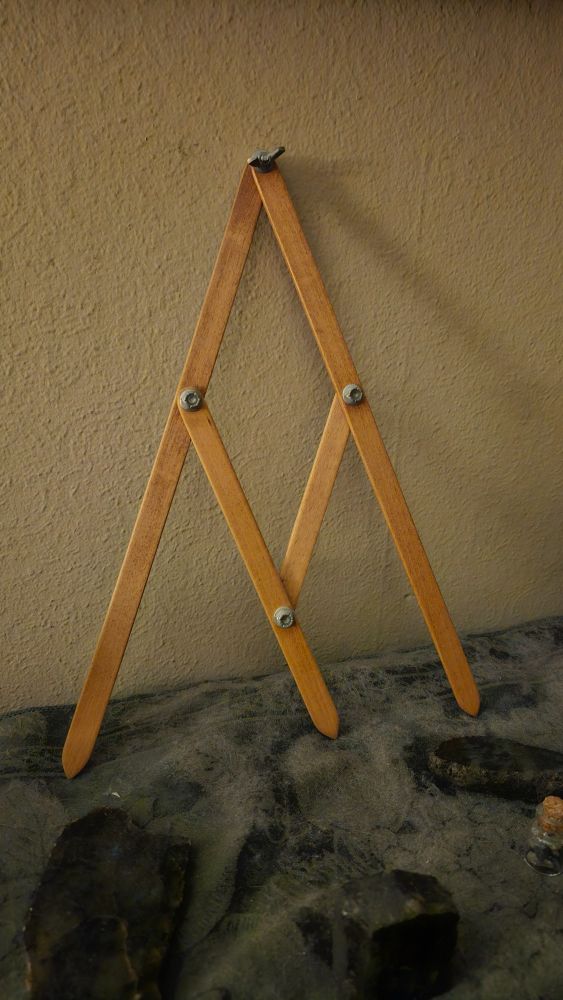 A set of wooden dividers or a compass, with a third pointer in the middle, which always divides the distance between the outer arms into the golden mean proportion.