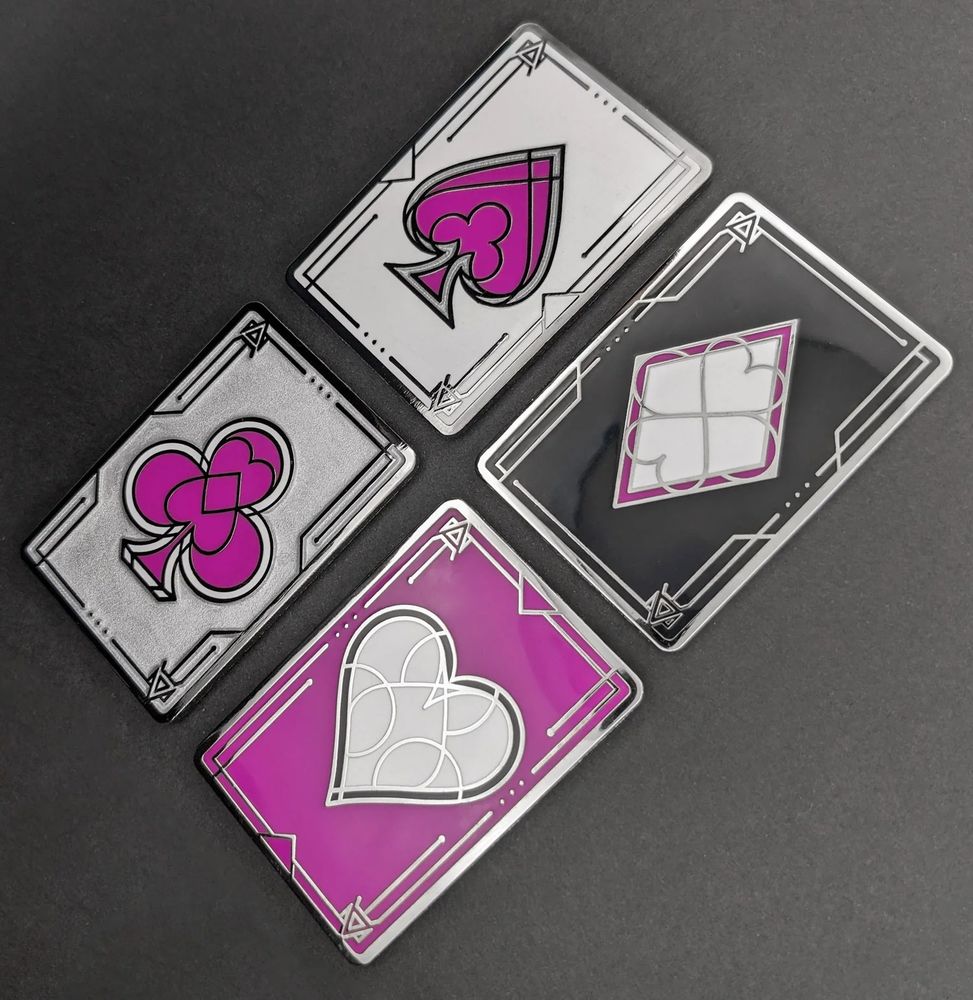 Four enamel pins depicting the ace of each of the poker suits. The colors of each pin are the Ace Pride colors: White, Grey, Purple, and Black.