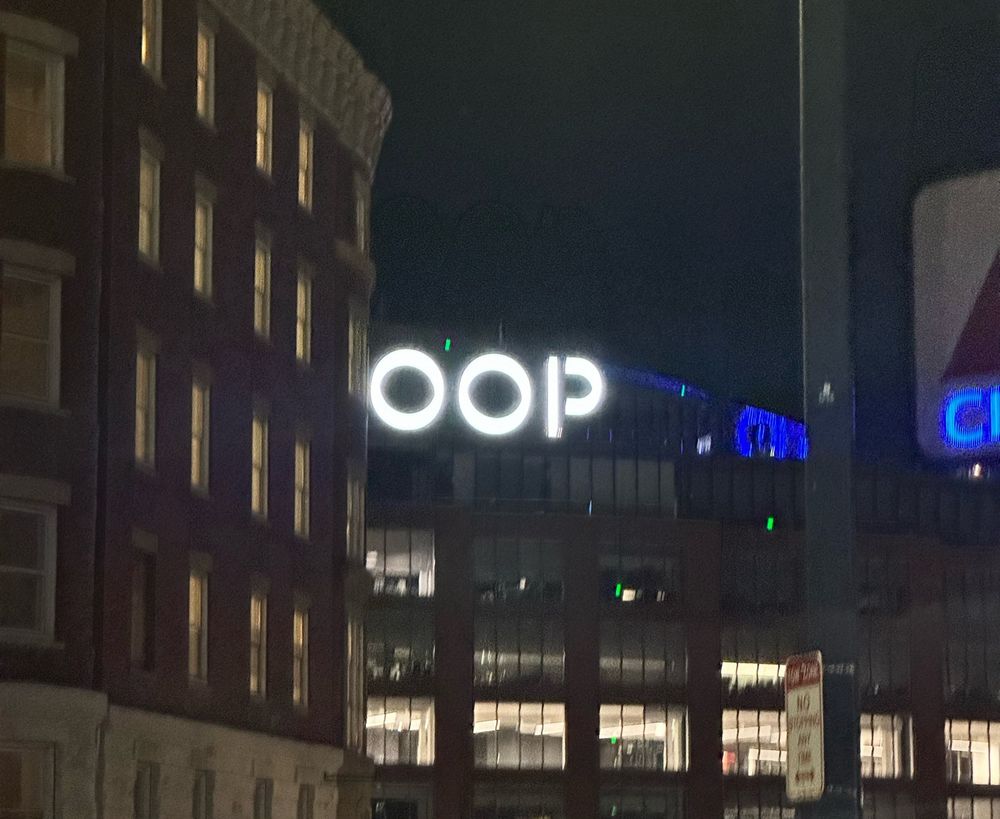 a white neon sign with the word “OOP” on top of a building