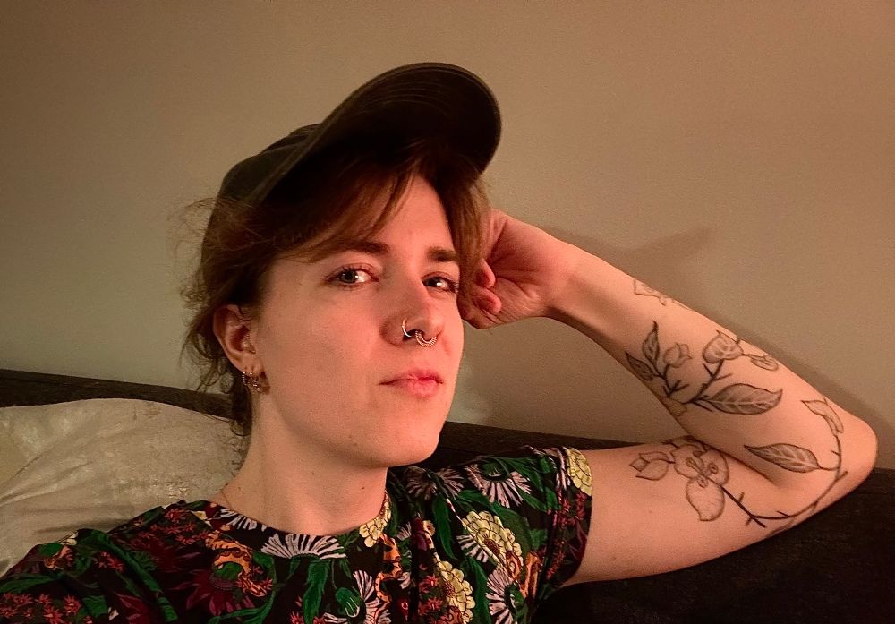 selfie of maddy now in a floral t shirt leaning on her left arm