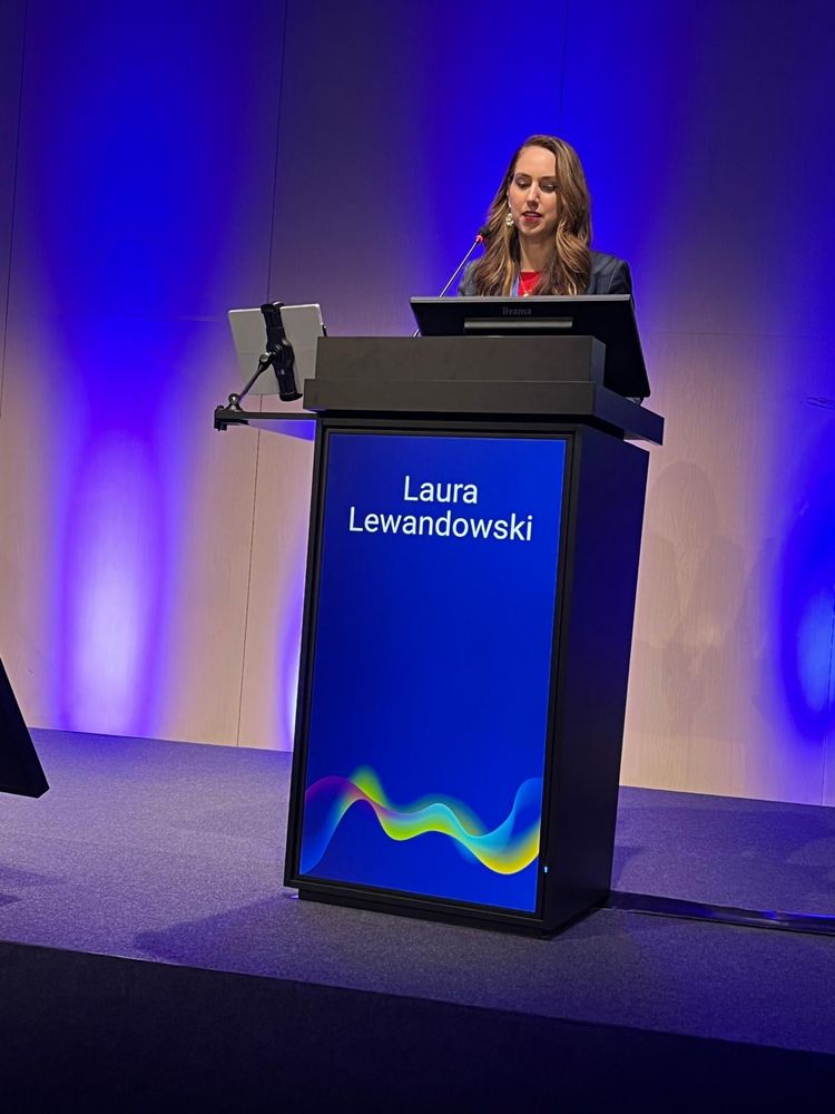 Dr Lewandowski stands at a podium presenting her talk.