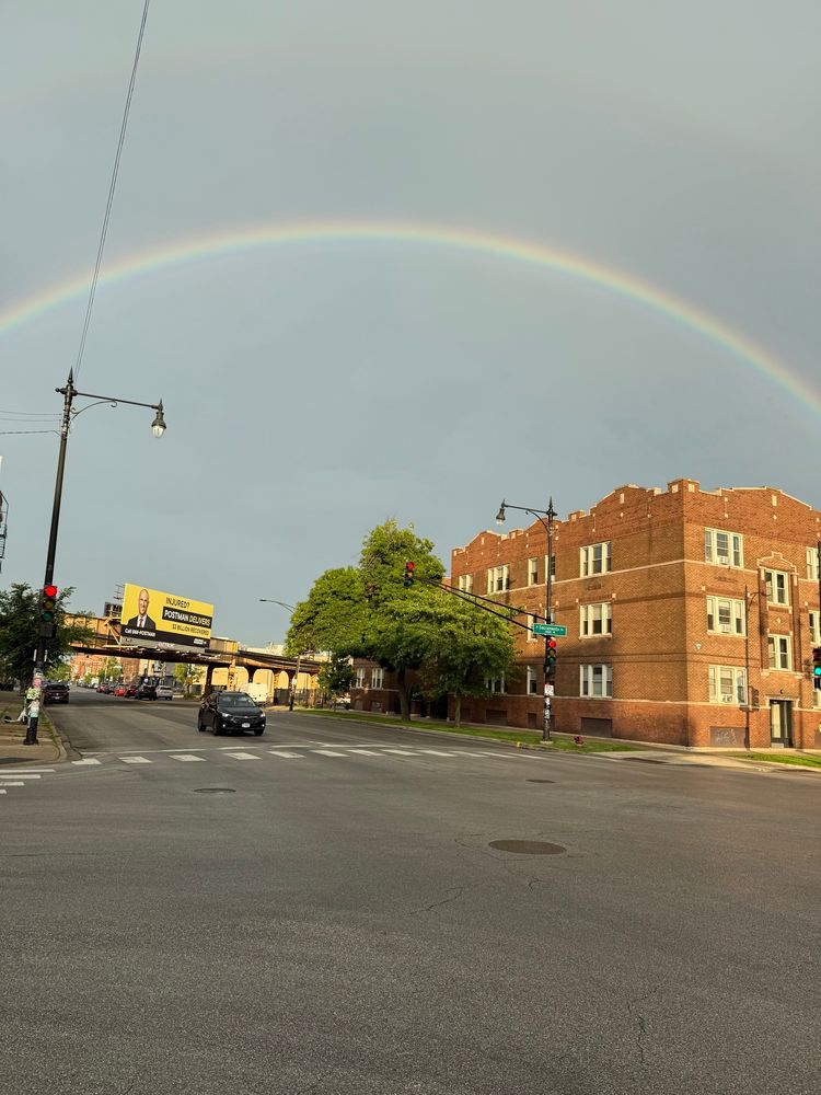 The same rainbow arcs over the CTA Blue line and nearby buildings.