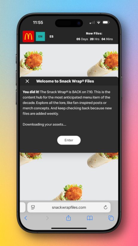 A screenshot showing SnackWrapFiles.com on an iPhone. The modal on the site announces that the Snack Wrap is back July 10