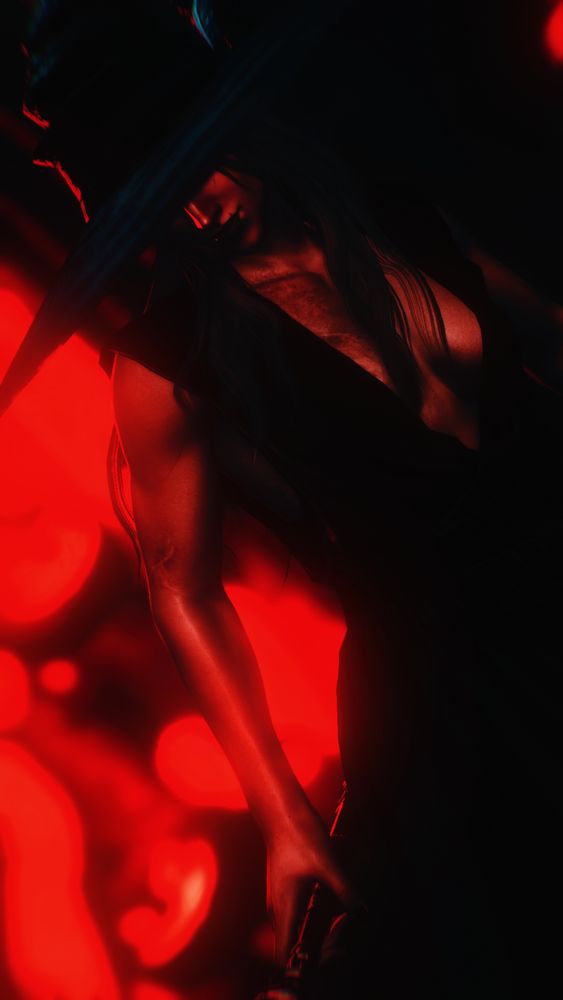 In the deep hues of red and black is Liseron at an angle. He is holding a staff and his face is covered by his large brimmed hat. The details of his outfit are indistinguishable, but it is pitch black with a deep v-neck from his shoulders to his stomach. His hair is loose and swaying with his form. 

Blurred in the background is the faint image of grinning pumpkins.