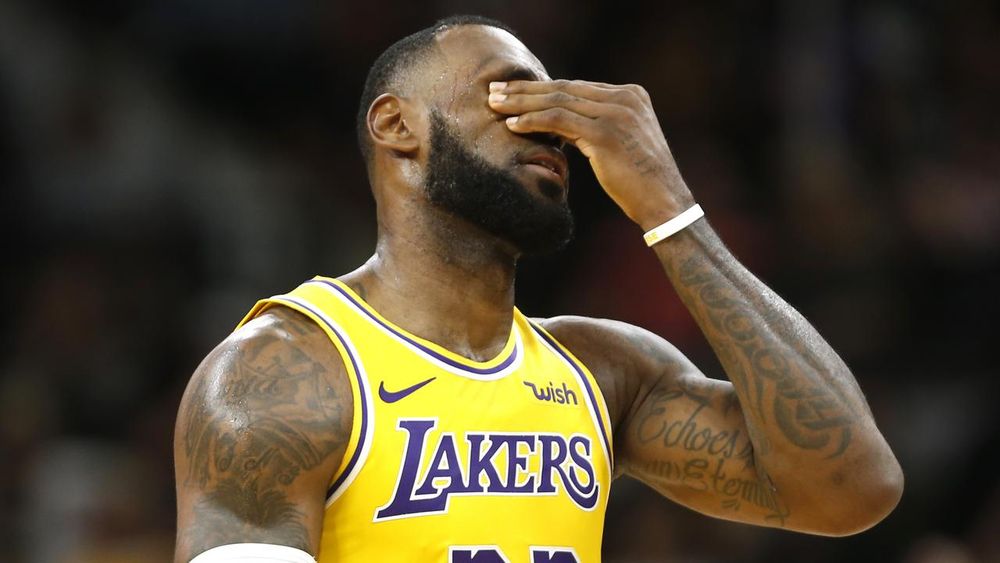 LeBron James covers his face and shame and dismay