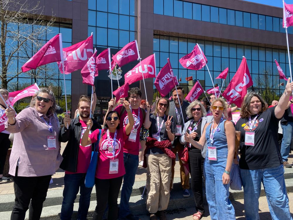 CUPE 3912 delegates with CUPE Nova Scotia flags in front of the city hall building 