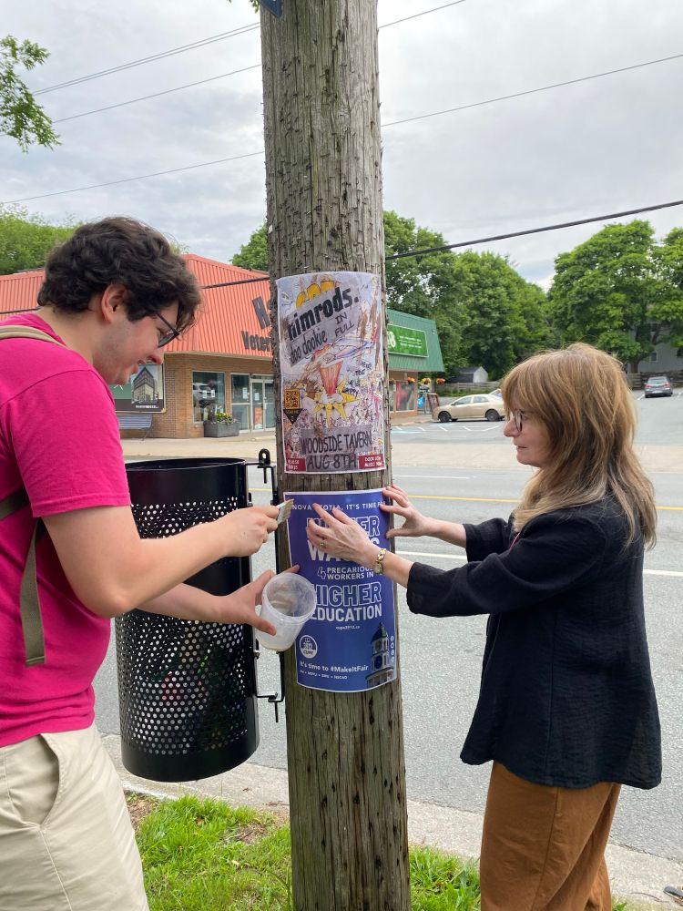 2 cupe 3912 members putting up posters on Quinpool Road