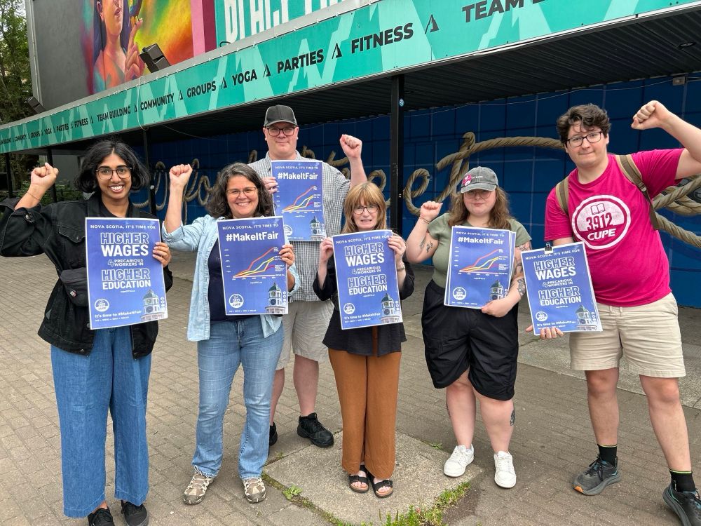 CUPE staff and members of Local 3912 holding their fist up and posters. One of then reads: Nova Scotia, is time for higher wages for precarious workers in higher education at Dalhousie, SMU, MSVU and NSCAD. The other one has a graph showing their salaries are and have been for 10 below the rate of inflation 