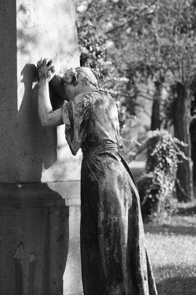 Das Bild zeigt eine Statue auf einem Friedhof.
Es zeigt eine stehende, weibliche Person, die sich mit der Stirn an einen hohen Grabstein lehnt, das Gesicht in der Armbeuge, die Hände gefaltet.
Der Künstler ist mir leider nicht bekannt.
Foto: Pixabay