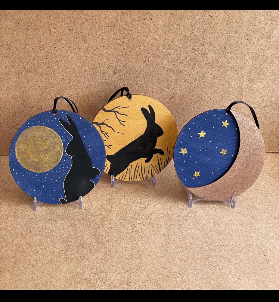 Three circles with blue and gold colours, two with rabbits and one with moon and stars