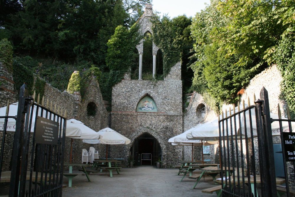 Stone gothic style facade with covered picnic tables and metal fencing