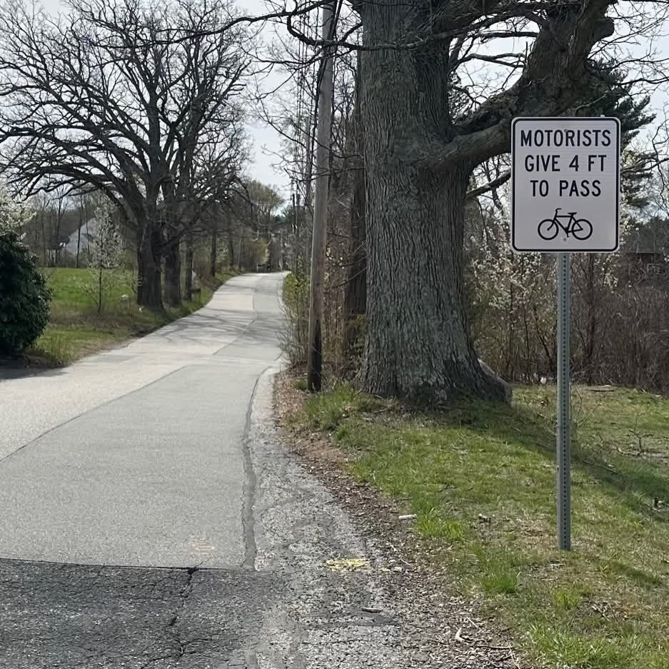 A sign that says Motorists Give 4 Feet to Pass