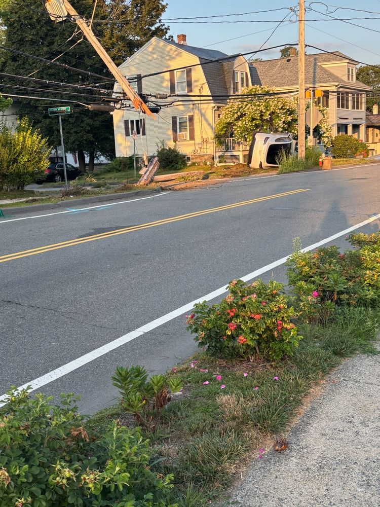 The same crash scene as the prior photo from a different angle. It shows a snapped telephone pole.