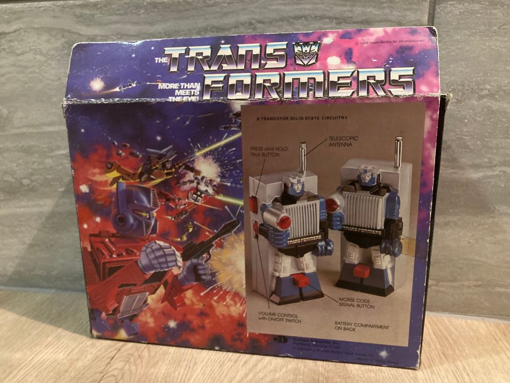 Back of the box featuring the 1984 box mural and a pic showing off the features of the walkies 