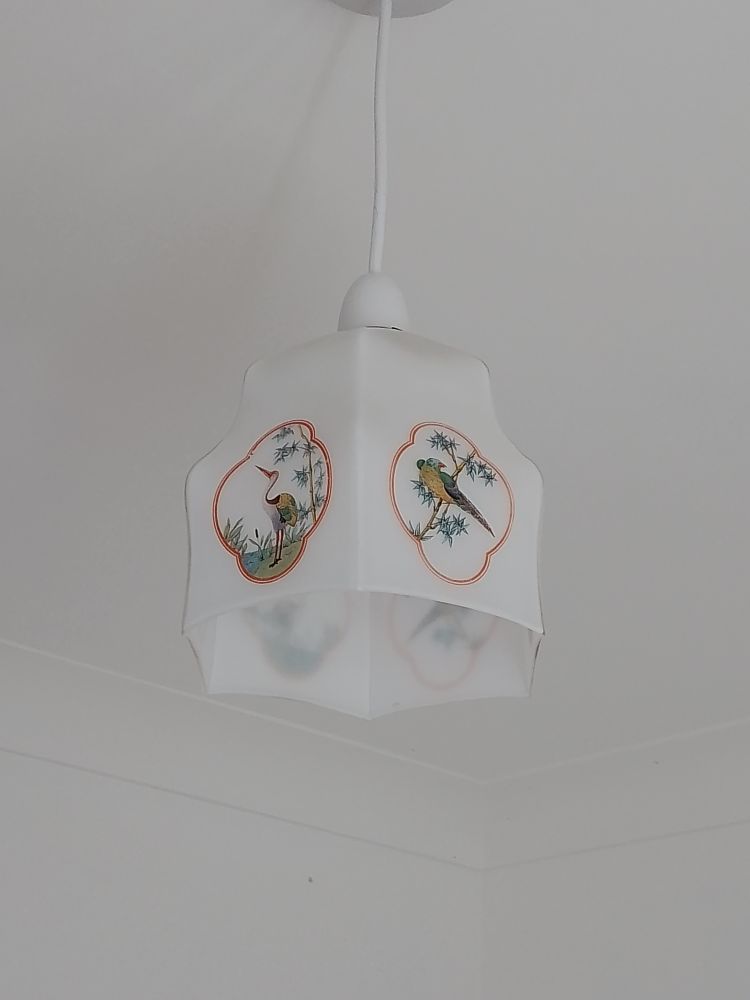 A vintage lampshade in a hexagonal shape in white frosted glass, decorated with cranes and finches amongst the bamboo leaves in orange lined cartouches. Japanese style. 