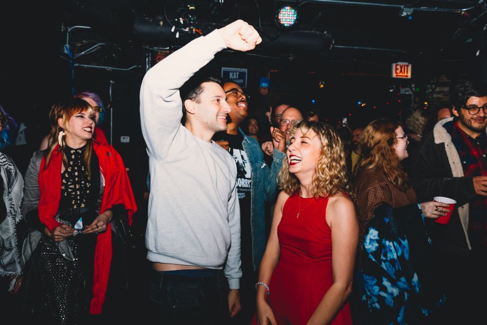 kat is laughing/smiling while ben and blue cheer