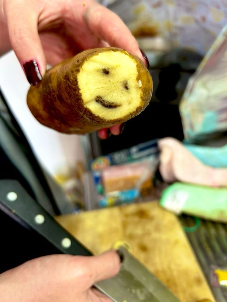 にっこり笑った顔のついたジャガイモの写真。