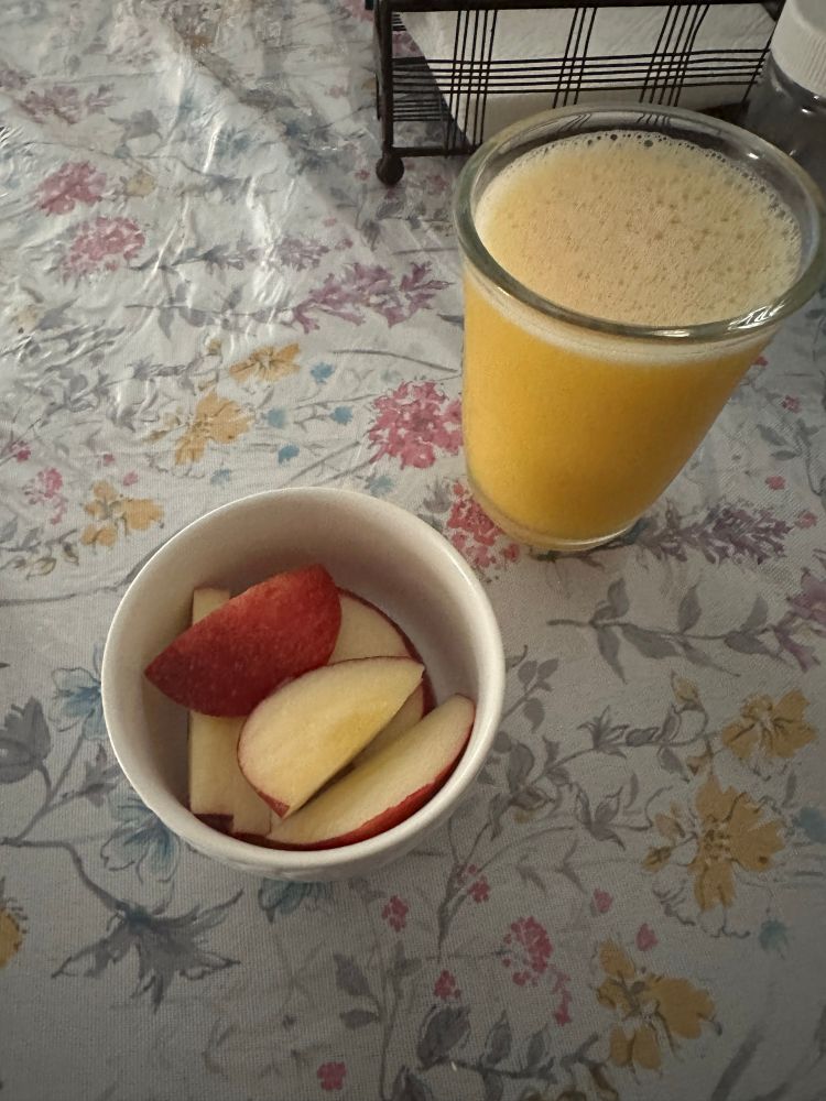a small bowl of apple slices and a glass of orange juice